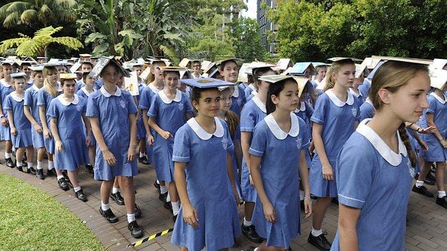 Students balancing books on their heads