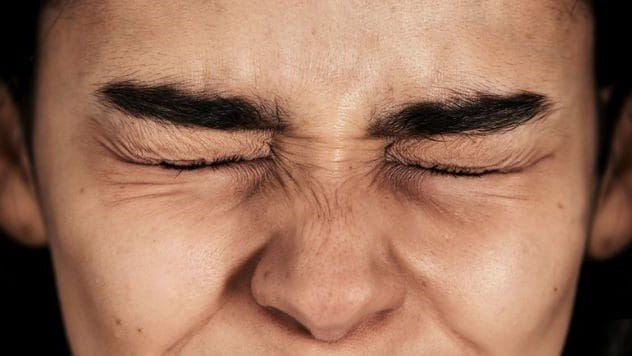 Person with hands covering their eyes