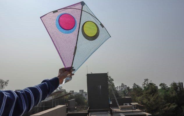 A boy flying kite near power lines