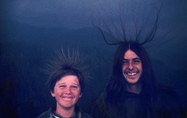 Siblings with hair standing on end before a lightning strike