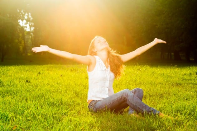 Person enjoying sunlight outdoors in nature