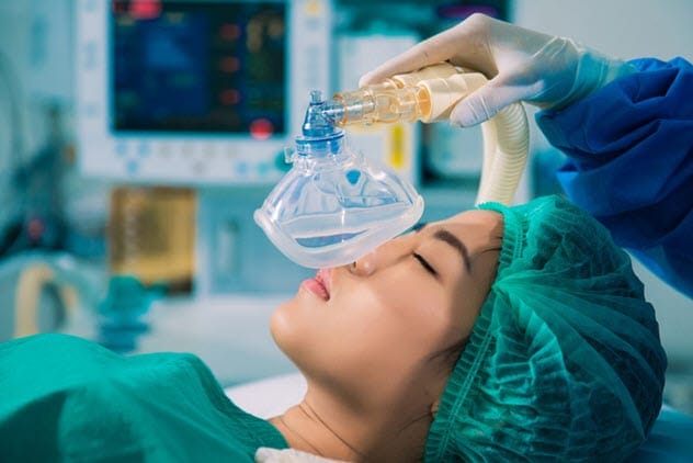 Medical professional administering anesthesia to a patient