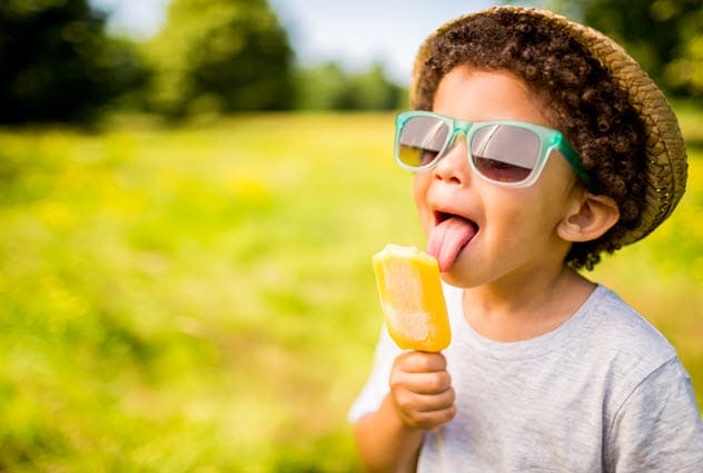 A boy eating a popsicle.