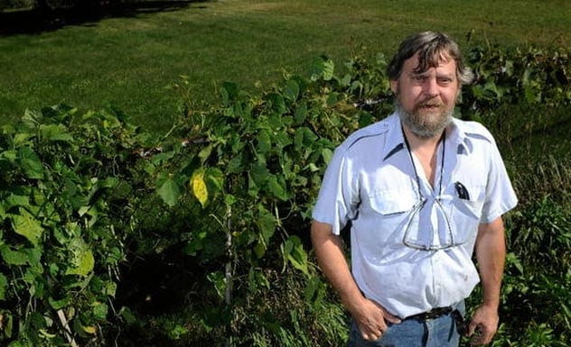 Wayne Sabaj holding a bag filled with bundles of cash