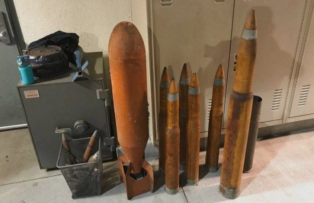 Various old, rusty military explosives like grenades and shells