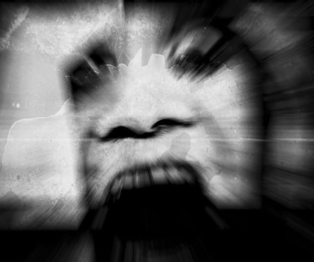 A ghostly figure screaming in a dark, eerie setting