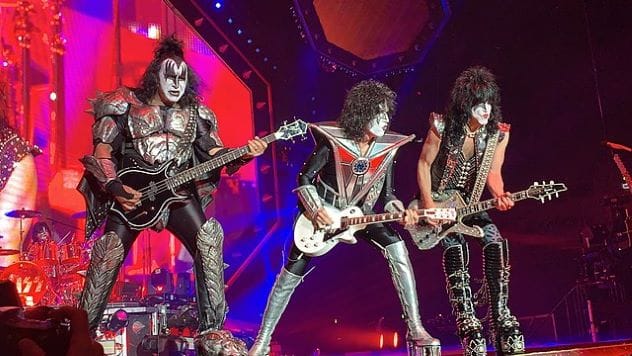 KISS band members performing on stage in elaborate costumes and makeup