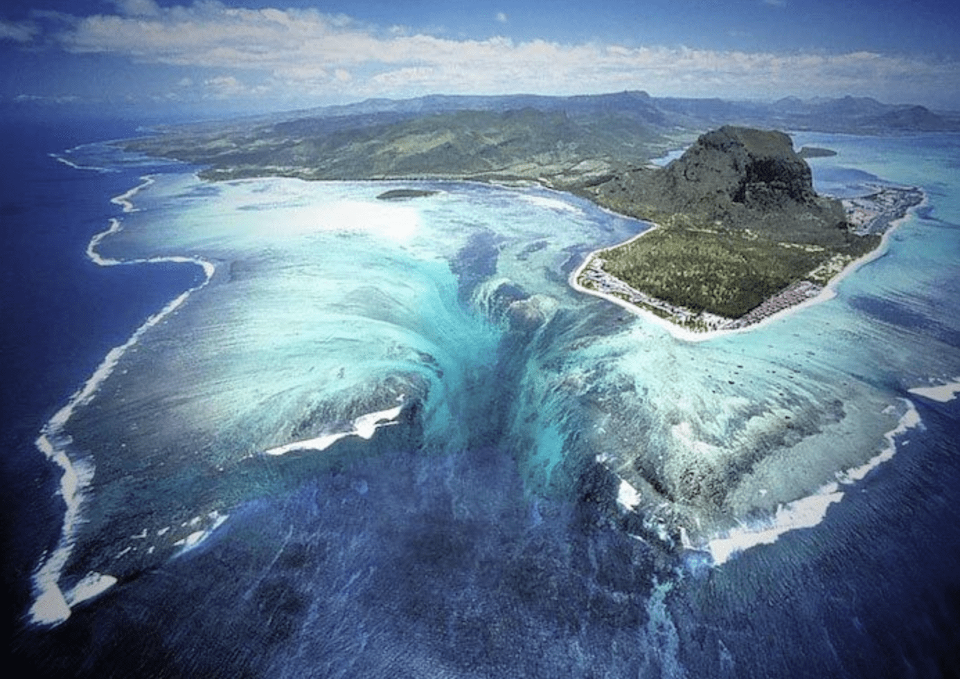 An aerial view of the stunning optical illusion of an underwater waterfall off the coast of Le Morne Peninsula, Mauritius.