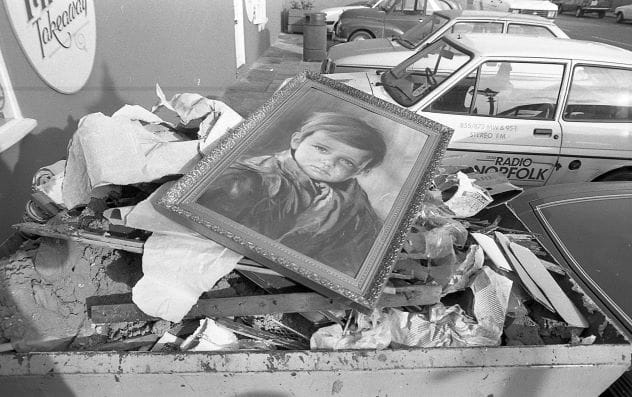 Newspaper clipping showing a firefighter with a Crying Boy painting