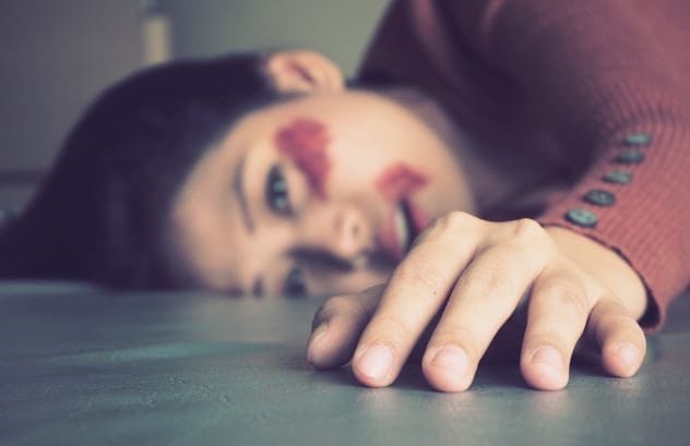 A dimly lit, empty college dorm hallway