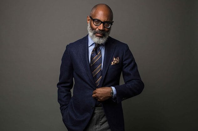 Man wearing a solid jacket, solid shirt, and patterned tie