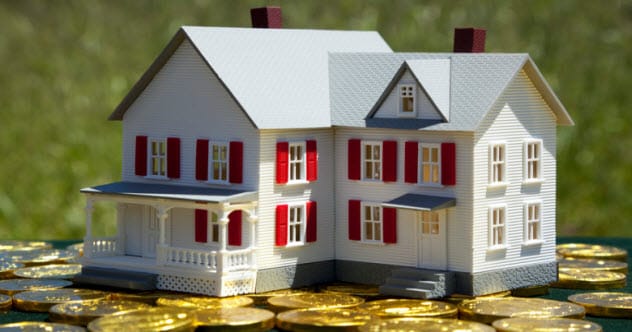 A dollhouse on a pile of money