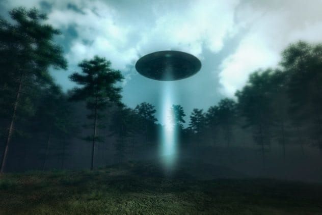 Silhouetted figure looking at a UFO in the night sky