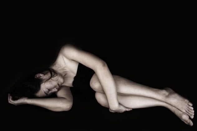 Hands reaching through a fence, symbolizing escape and trafficking