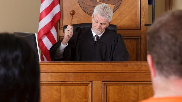 A judge's gavel and sound block on a wooden surface