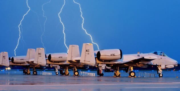 Lightning striking near an airplane in a stormy sky