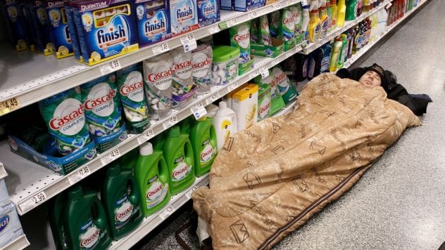 Man asleep on the floor of a store aisle after committing a theft