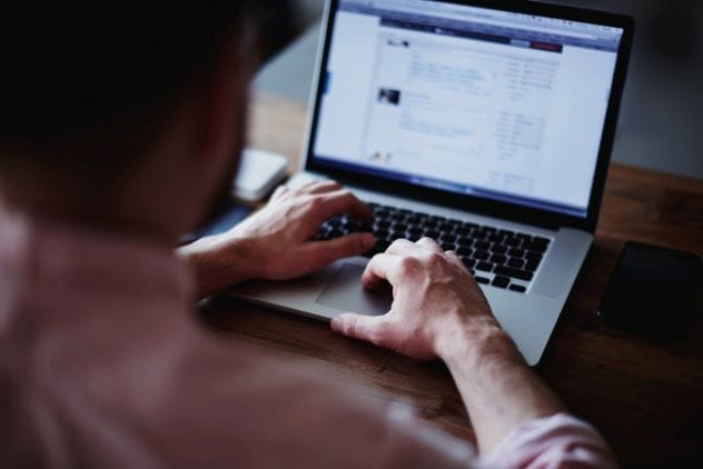 Man using a laptop, symbolizing checking Facebook at a crime scene
