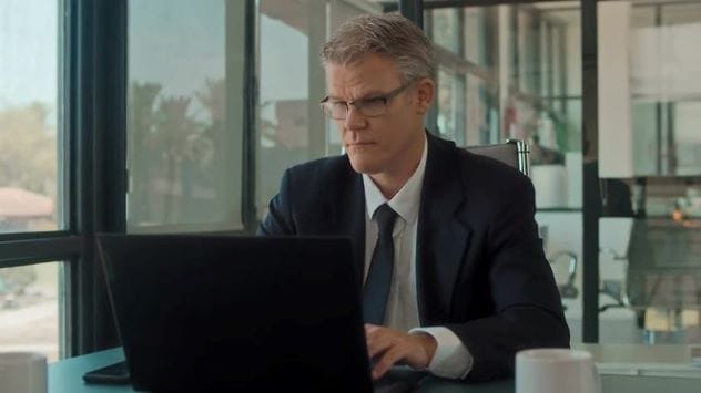 Man typing on a laptop, symbolizing online discussions and potential monitoring on Reddit.