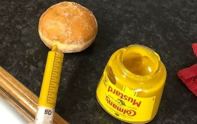 Box of doughnuts, one with a suspicious yellow filling hinting at mustard