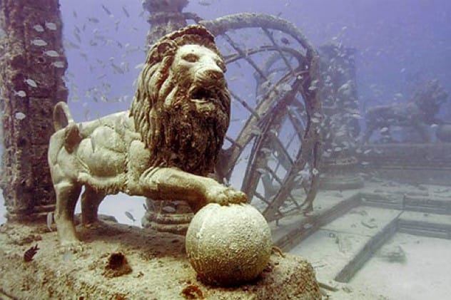 Underwater view of the Neptune Memorial Reef with statues and columns.