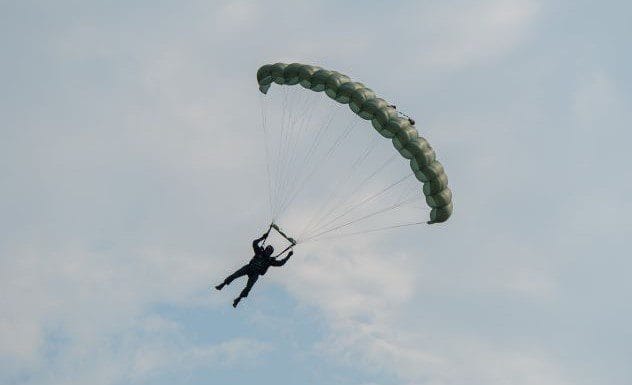 Silhouettes of soldiers parachuting from a plane, relevant to YTK's past life claims
