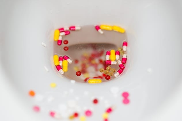 Pills being flushed down a toilet
