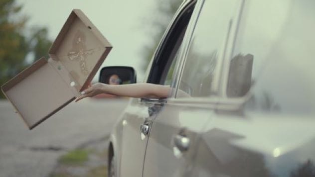 Pizza box on a car windshield, symbolizing an accident