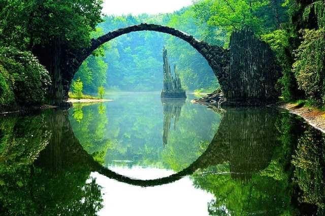 Rakotzbrücke, also known as Devil's Bridge, creating a perfect circle with its reflection in Kromlau Park, Germany.