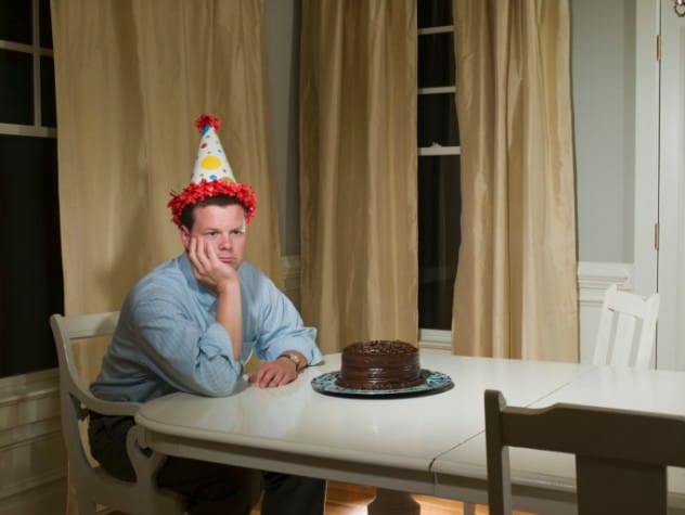 Children at a birthday party with cake and balloons