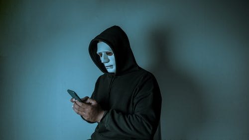 A shadowy figure with a white mask, evoking the Slender Man legend