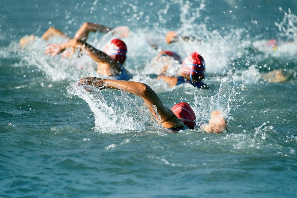 Swimmers competing in an open water triathlon event.