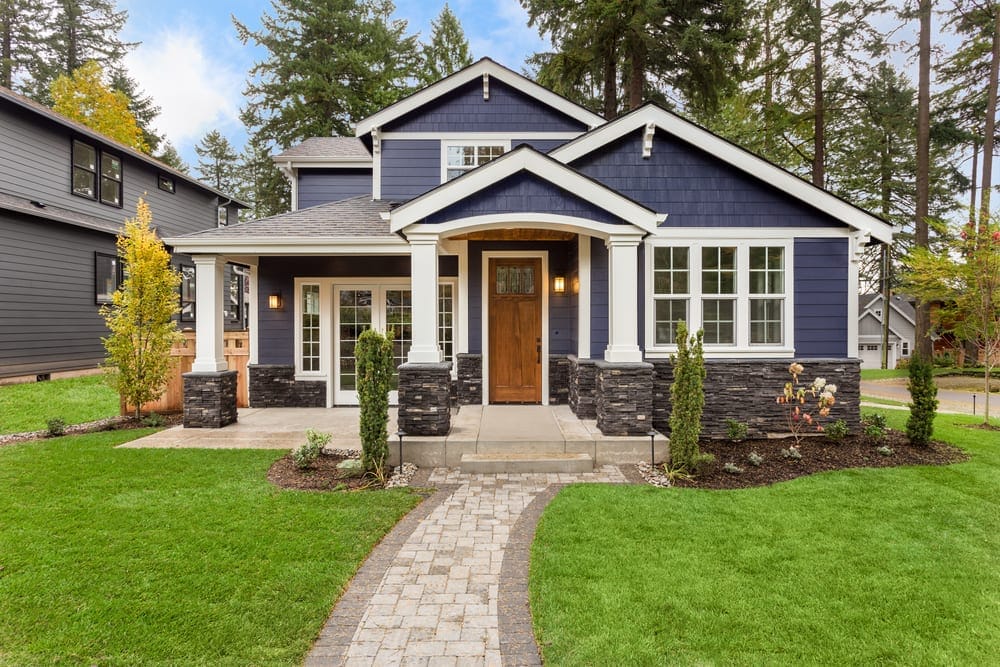 A house in a suburban neighborhood with a 'For Sale' sign