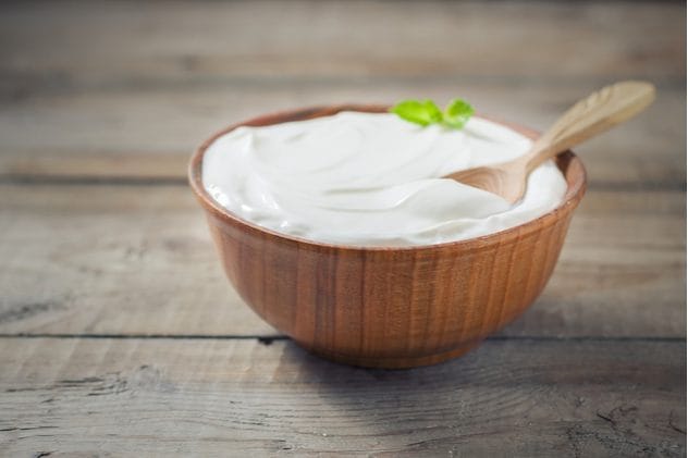 Bowl of plain yogurt with berries, a gentle food for hangover recovery