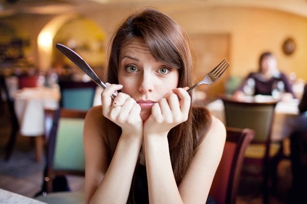 Couple looking tense and unhappy outside a restaurant