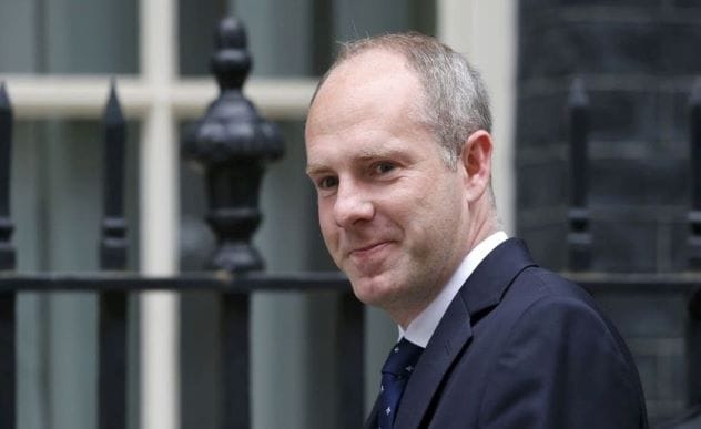 Justin Tomlinson MP, smiling, in a suit and tie.