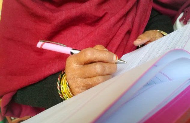A woman writing in a notebook, possibly alluding to Shiva Tripathi's newfound literacy